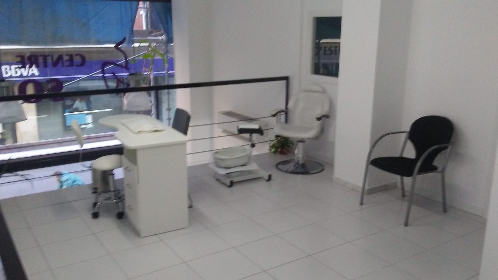 Zona de manos y pies con la mesa de manicura, el sillón de pedicura y el escaparate