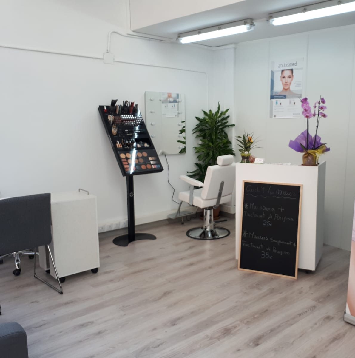 Recepción del centro con la pizarra de manicura, el expositor de maquillaje y una orquídea en el mostrador